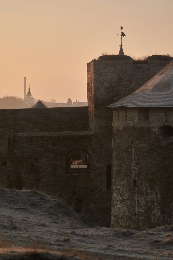 Mura e torre di un castello al tramonto