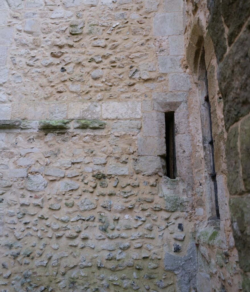 Un muro di pietra con una feritoia