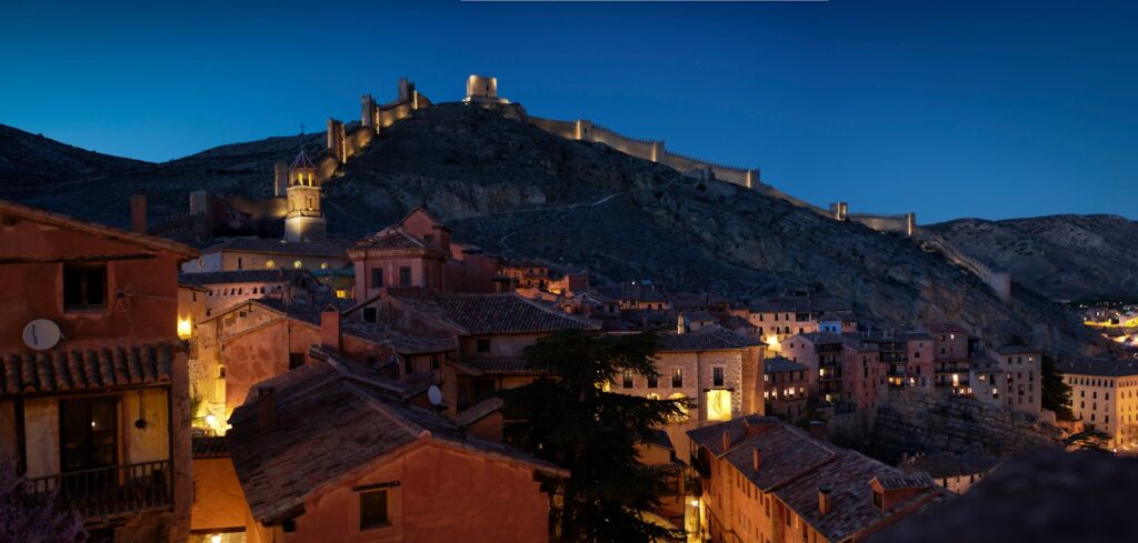 Un borgo illuminato sotto il castello, al crepuscolo
